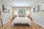 This serene bedroom offers a tranquil retreat with its neutral color palette and natural wood accents.