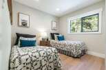 This charming bedroom features two twin beds adorned with stylish geometric-patterned quilts and plush decorative pillows.