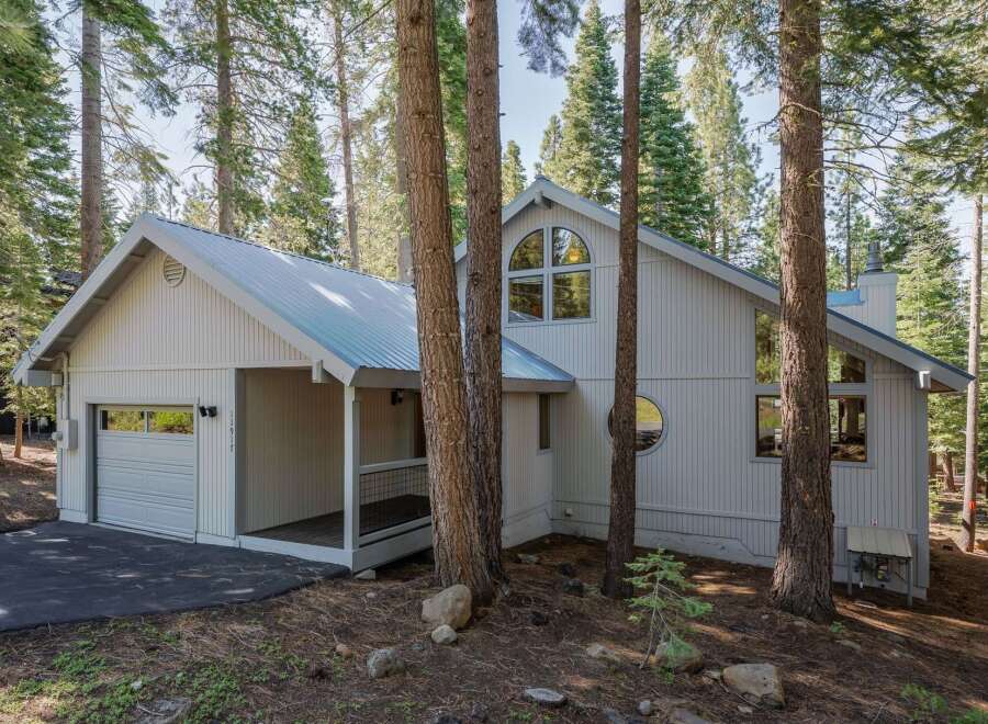 Nestled amongst tall pine trees, this charming home offers a serene mountain retreat.