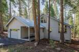 Nestled amongst tall pine trees, this charming home offers a serene mountain retreat.