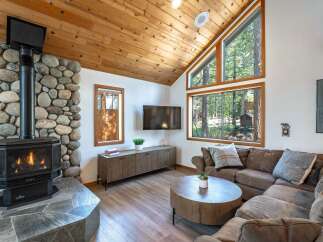 Cozy living room featuring a large stone fireplace with a gas insert, perfect for chilly evenings.