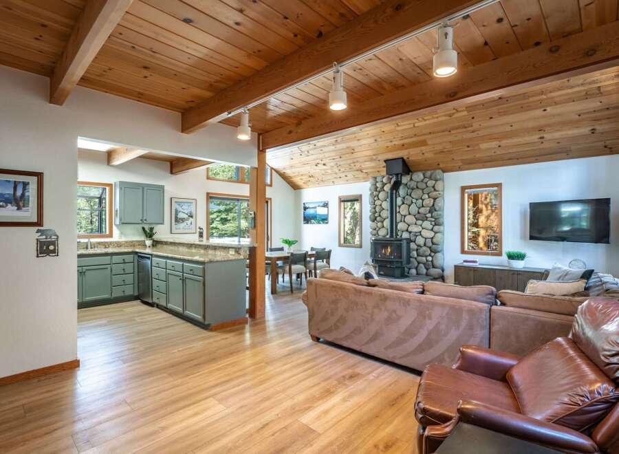 Experience cozy living in this charming mountain retreat, featuring a stunning stone fireplace as the centerpiece of the living area.