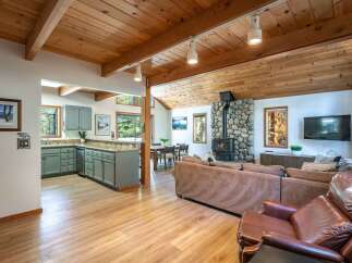 Experience cozy living in this charming mountain retreat, featuring a stunning stone fireplace as the centerpiece of the living area.