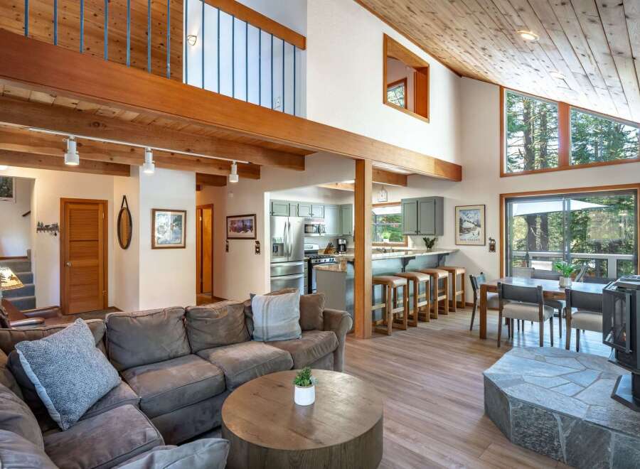 Experience mountain living in this stunning home featuring a spacious open-concept living area with vaulted wood ceilings and a cozy fireplace.
