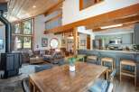 Experience cozy living in this charming mountain retreat, featuring a spacious open-concept living area with a striking wood-burning stove and vaulted, wood-paneled ceilings.