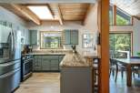 Experience rustic charm in this spacious kitchen featuring sleek grey cabinetry and a stunning granite countertop breakfast bar.