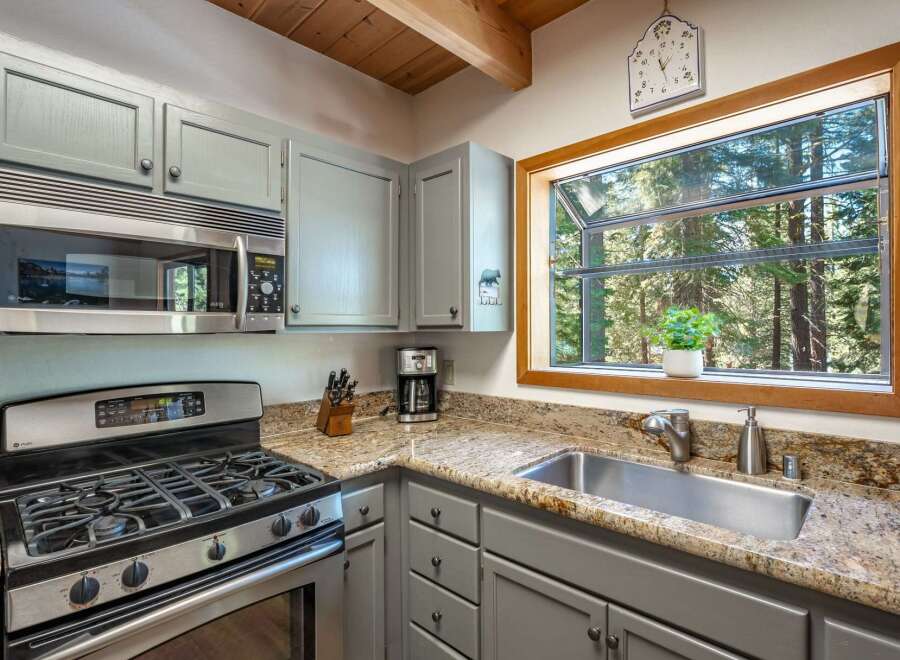 This cozy kitchen features a stainless steel gas range and microwave, perfect for preparing meals.