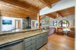 Experience rustic charm and modern comfort in this inviting living space, featuring a stunning stone fireplace and a vaulted wood-paneled ceiling.
