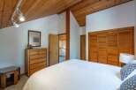 Discover this charming bedroom featuring a vaulted wood-paneled ceiling and ample natural light.