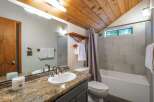 This charming bathroom features a granite countertop vanity with a white sink and modern chrome fixtures.
