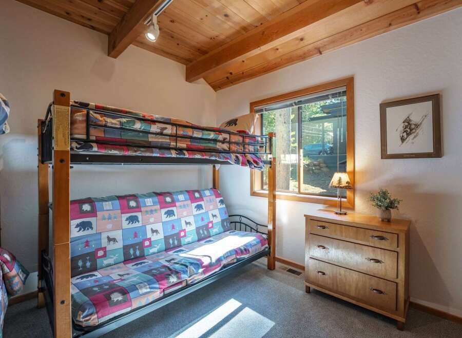 This charming bedroom features a versatile bunk bed with a futon, perfect for accommodating guests or family.