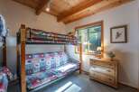 This charming bedroom features a versatile bunk bed with a futon, perfect for accommodating guests or family.