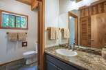 This bathroom features a charming rustic design with warm wood accents and natural stone flooring.