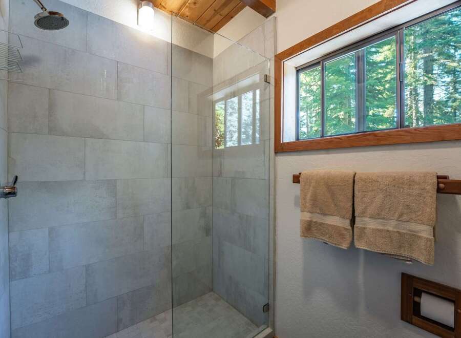 Experience a spa-like retreat in this modern bathroom, featuring a spacious glass-enclosed shower with elegant tilework.