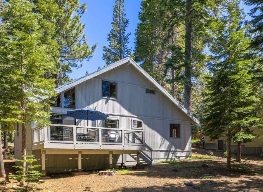 Nestled among tall pine trees, this charming home offers a serene mountain retreat.