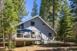 Nestled among tall pine trees, this charming home offers a serene mountain retreat.