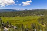 Discover this stunning property nestled amidst a vast evergreen forest, offering breathtaking views of snow-capped mountains in the distance.