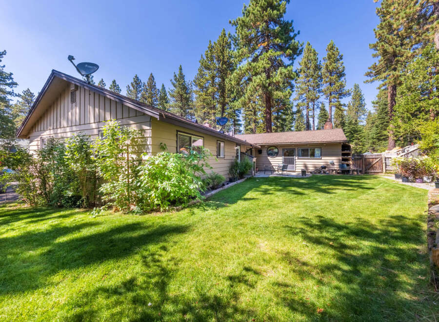 Enjoy the serene backyard of this charming home, complete with a lush green lawn perfect for outdoor activities.