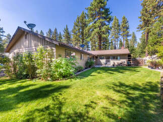 Enjoy the serene backyard of this charming home, complete with a lush green lawn perfect for outdoor activities.