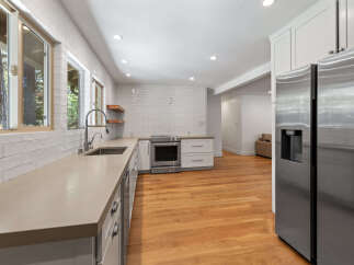 Discover this beautifully renovated kitchen featuring sleek white subway tile backsplash and durable quartz countertops.