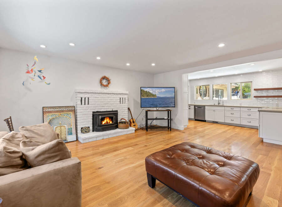 Experience comfortable living in this inviting living room, featuring a cozy brick fireplace and a large, plush sofa perfect for relaxation.