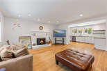 Experience comfortable living in this inviting living room, featuring a cozy brick fireplace and a large, plush sofa perfect for relaxation.