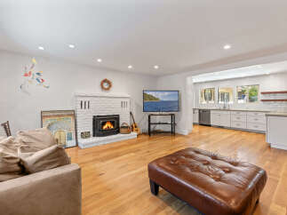 Experience comfortable living in this inviting living room, featuring a cozy brick fireplace and a large, plush sofa perfect for relaxation.