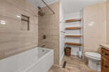 This modern bathroom features a sleek white bathtub with a built-in niche, complemented by elegant beige subway tile walls.
