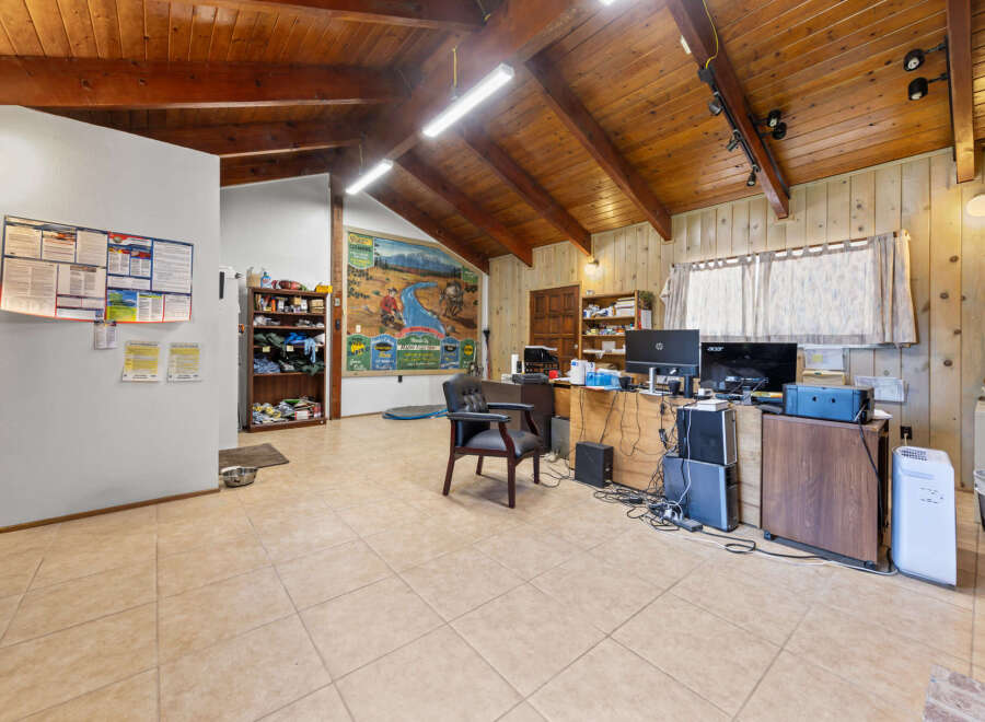 Discover a versatile space with a rustic charm, featuring a vaulted wood-paneled ceiling and ample natural light.