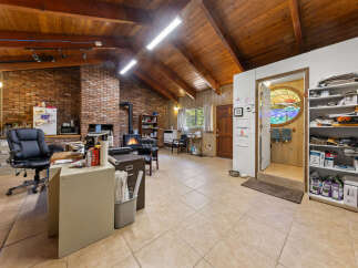 Discover a unique living space with a rustic charm, featuring a soaring wood-beamed ceiling and exposed brick walls.