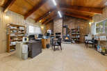 Discover a spacious and inviting office space featuring a cozy brick fireplace with a wood-burning stove, perfect for creating a warm atmosphere.