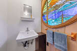 Discover a charming bathroom featuring a unique stained-glass window that adds a touch of artistry and color to the space.