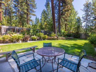 Enjoy outdoor living in this charming backyard featuring a spacious patio area perfect for al fresco dining.