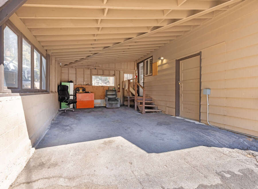 Discover versatile outdoor living space with this covered carport, perfect for protecting vehicles or creating a shaded recreational area.