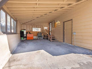 Discover versatile outdoor living space with this covered carport, perfect for protecting vehicles or creating a shaded recreational area.
