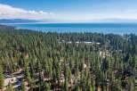 Experience the serene beauty of Lake Tahoe with this stunning aerial view of a property nestled amidst a dense pine forest.
