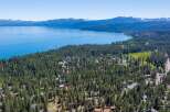 Discover this stunning aerial view of a lakeside community nestled amidst a dense pine forest.