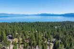 Experience breathtaking lake and mountain views from this stunning property nestled amongst a dense forest of pine trees.