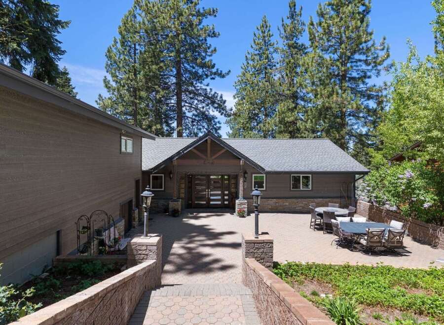 Discover this stunning mountain retreat featuring a spacious paver patio perfect for outdoor entertaining, complete with multiple seating areas and dining sets.