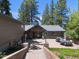Discover this stunning mountain retreat featuring a spacious paver patio perfect for outdoor entertaining, complete with multiple seating areas and dining sets.