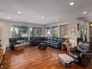 Experience breathtaking mountain views from this spacious living room, featuring a large sectional sofa and comfortable leather recliners.