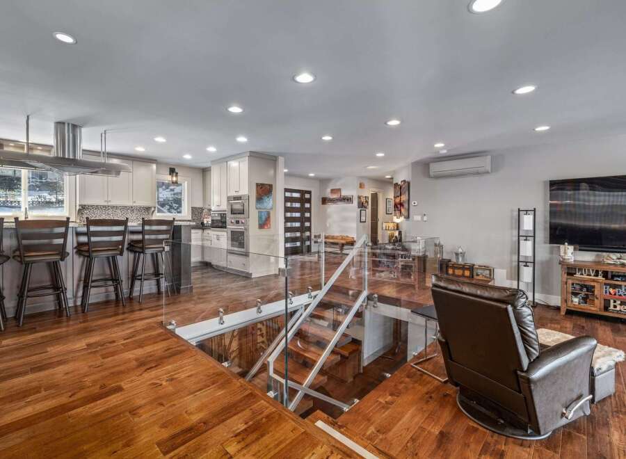 Experience modern living in this stunning open-concept home featuring a sleek kitchen with a large island and bar seating, perfect for entertaining.