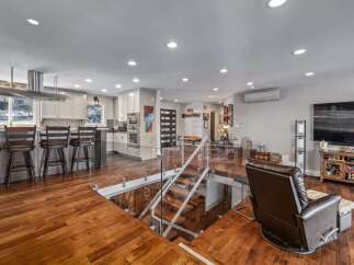 Experience modern living in this stunning open-concept home featuring a sleek kitchen with a large island and bar seating, perfect for entertaining.