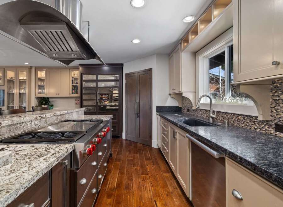 Experience culinary excellence in this gourmet kitchen, featuring a professional-grade gas range and a spacious granite island perfect for meal prep and entertaining.