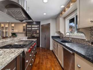 Experience culinary excellence in this gourmet kitchen, featuring a professional-grade gas range and a spacious granite island perfect for meal prep and entertaining.