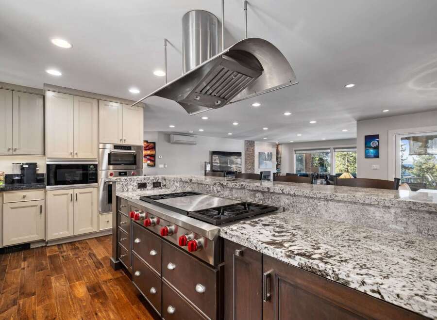 Experience luxury in this stunning kitchen featuring a professional-grade gas range with a sleek stainless steel hood.