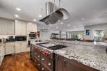 Experience luxury in this stunning kitchen featuring a professional-grade gas range with a sleek stainless steel hood.