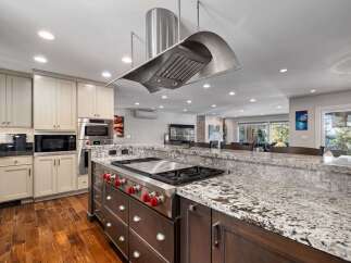 Experience luxury in this stunning kitchen featuring a professional-grade gas range with a sleek stainless steel hood.