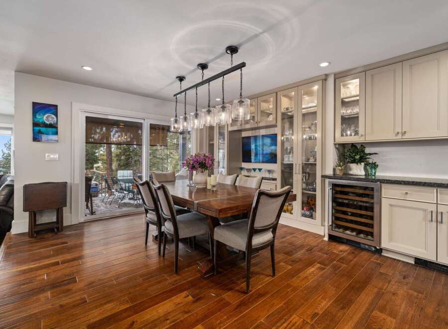 Experience elegant dining in this spacious room, featuring a large wooden table with comfortable upholstered chairs, perfect for hosting gatherings.
