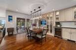 Experience elegant dining in this spacious room, featuring a large wooden table with comfortable upholstered chairs, perfect for hosting gatherings.